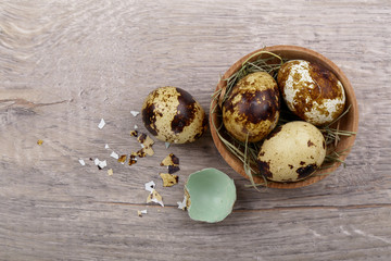 Quail eggs and eggshell on a wooden background.