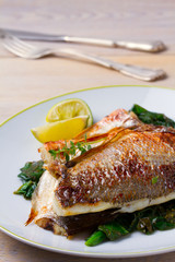 Dorado or dorada fish fillet with spinach, thyme and lime, vertical