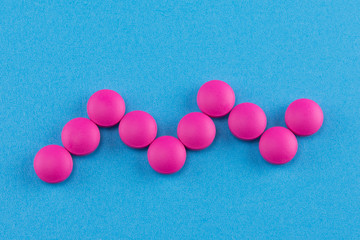 pink pills on blue background