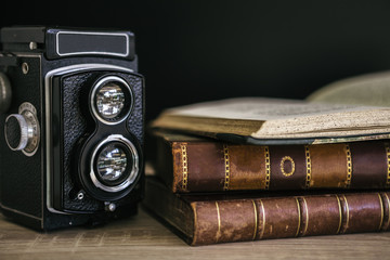 Close-up of old camera and stack of books