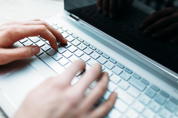 Hands close-up, typing on the laptop keyboard