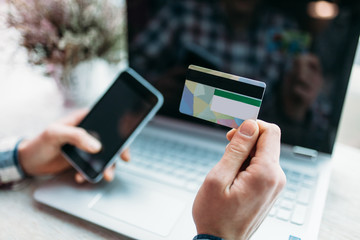 Young man with credit card payments through the Internet, finding the item on the Internet