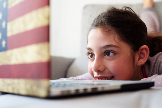 LIttle girl using her laptop at home