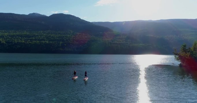 Couple rowing a stand up paddle board in the river 
