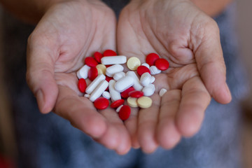 Hand holding several pills
