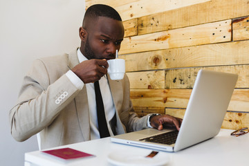 Young African working with a laptop in a trendy cafe
