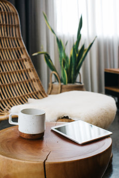 Digital Tablet and Ceramic Mug Standing on Coffee Table in Stylish Living Room