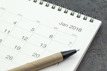 Jan 2018 clean calendar with pen on black  background using as year resolutions, target or goals