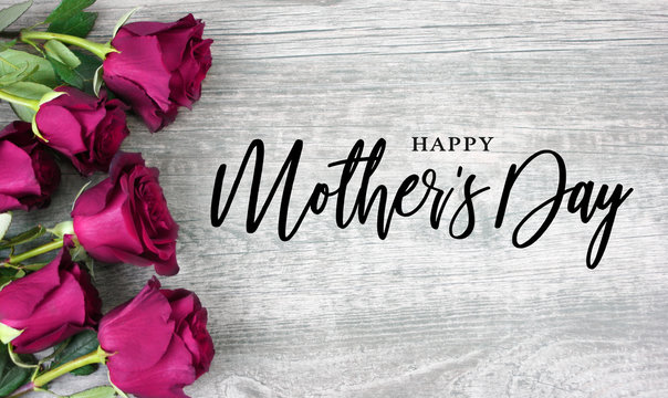 Happy Mother's Day Calligraphy with Pink Roses Over Rustic Wood Background