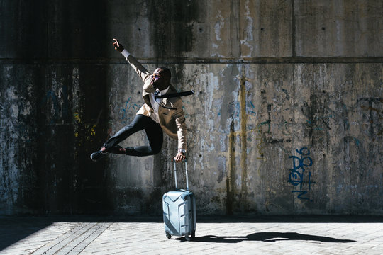 African businessman jumping over a suitcase