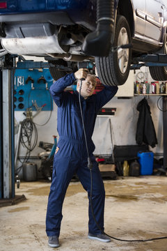Mechanic Fixing Wheel On Car In Garage