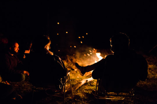 Friends sitting around the campfire at night