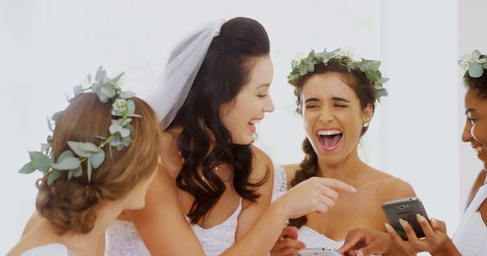 Bride and bridesmaids laughing at there photos  
