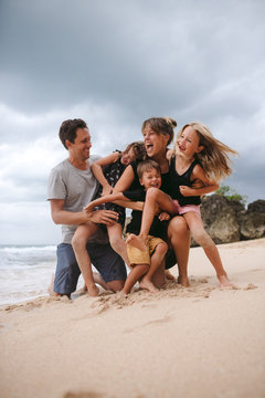 Happy family of five playing on beach
