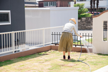 庭の水撒きをする女性