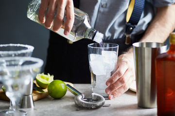 Bartender pouring tequila in glass.