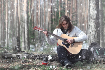 Guitarist in the woods at a picnic. A musician with an acoustic 