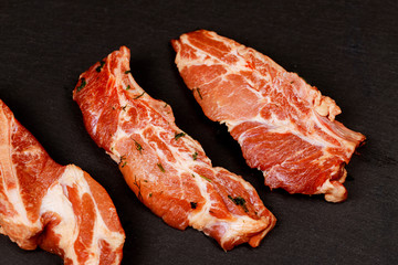 Meat. Raw pieces of pork a black background. Selective focus. Top view.