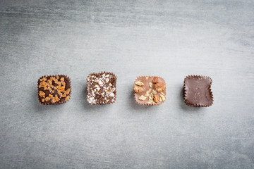 Several kinds of chocolate treats on a stone background.