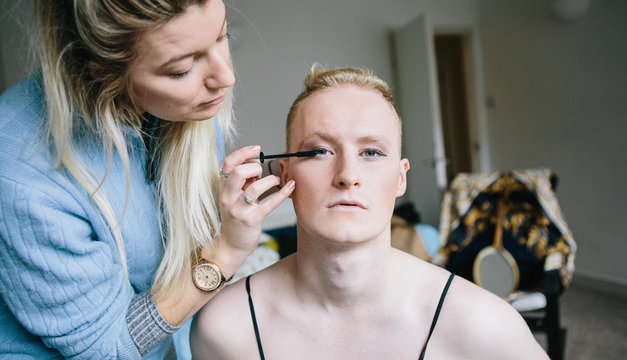 Woman applies mascara to friend's eyes