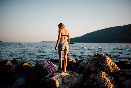 Woman Sun Tanning On A Rocky Beach