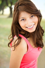 Young Hispanic girl smiling outside.