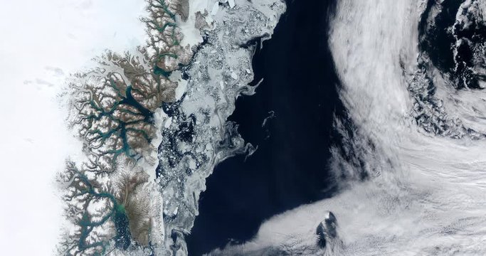 Very high-altitude overflight aerial of sea ice along the eastern coast of Greenland. Clip loops and is reversible. Elements of this image furnished by USGS/NASA Landsat