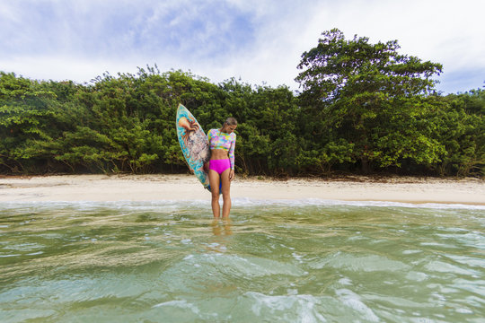 Female surfer standing at the baech