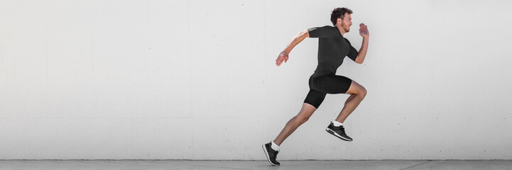 Running man runner training doing outdoor city run sprinting along wall background. Urban healthy active lifestyle. Male athlete doing sprint hiit high intensity interval training. Banner panorama.