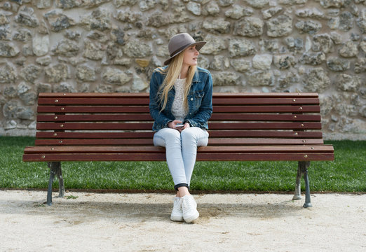 Woman with phone on bench