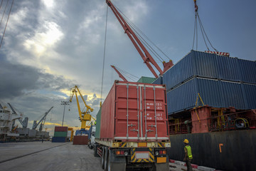 truck trailer or lorry delivery unit of containers from storage yard to the ship in the port terminal where sea and land transport meet together being for logistics services to global worldwide