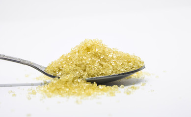 Close-up brown sugar in a spoon on white background