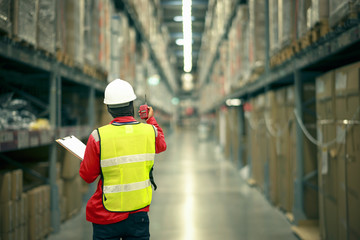 male manager using handheld in a large warehouse  worker checking delivering boxes. distribution center. logistics concept.