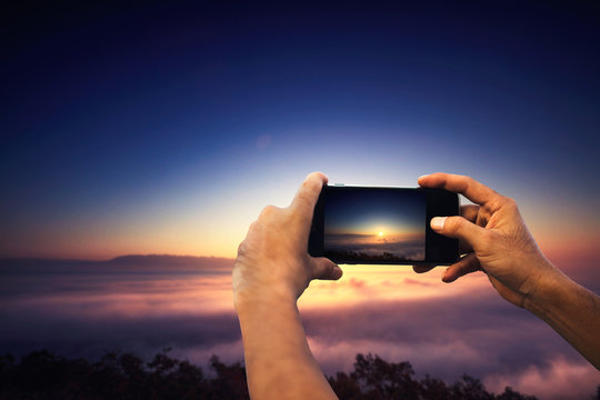 Closeup on traveller man taking photo with smart phone on mountain, amazing summer foggy landscape, mountains, beauty photo