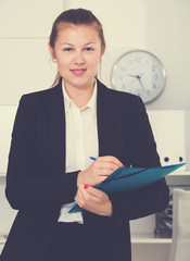 Manager woman in black suit is signing agreement papers of financial nature