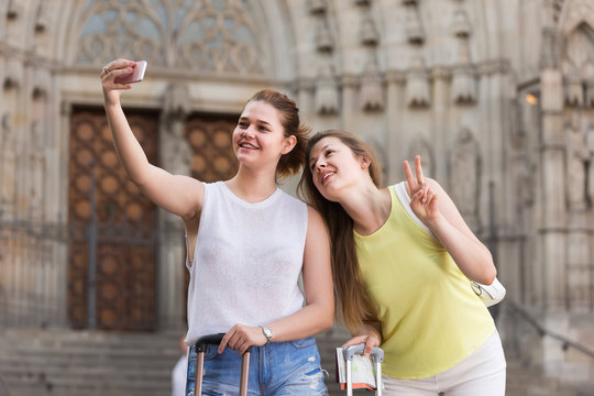 tourists walking in the town and taking selfie on phone