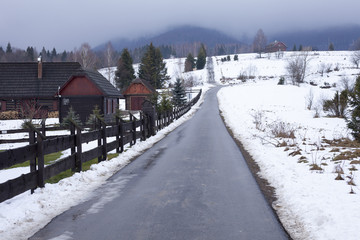 Road in Bieszczady to Wetlina and Solina, Winter day with lot of snow. Buildings in the background