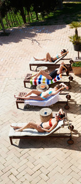 Girls sunbathing on deckchairs.