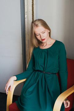 Young blonde woman wearing green dress
