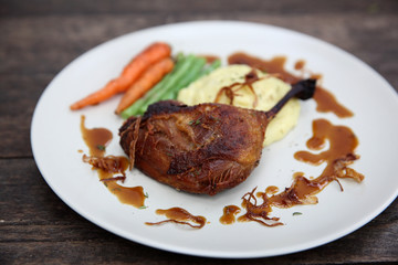 duck confit , Grilled duck steak with carrot and asparagus on wood background