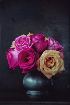 Overblown roses in a pewter jug