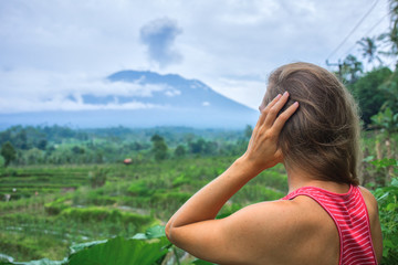 Woman is looking at Agung volcano eruption in Bali, Indonesia