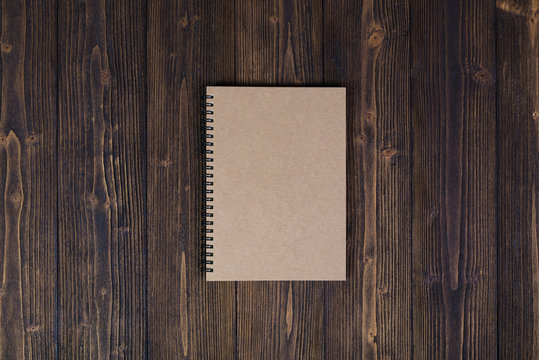 Notebook on wood table top view with copy space.