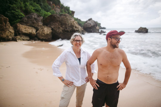 Happy woman and mother with adult son on tropical beach