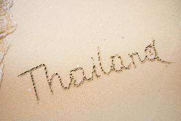 Thailand word is written on the beach sand
