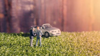 Obraz premium two miniature businessman people handshake