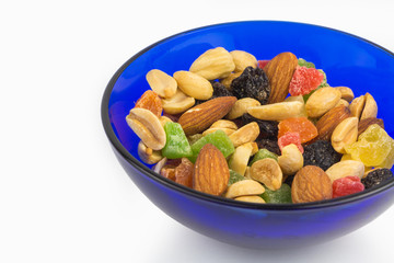 Fototapeta premium Dried fruits and nuts in blue bowl, proper nutrition, closeup