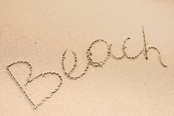 Beach word is written on the beach sand
