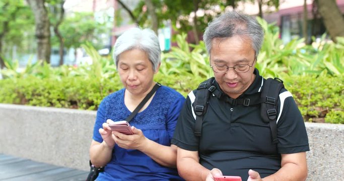 Senior couple using mobile phone together