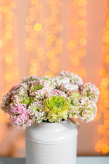Pink persian buttercup flowers. Curly peony ranunculus in Metallic gray vintage can. Vase with beautiful bouquet on table. Copy space. lights on the background